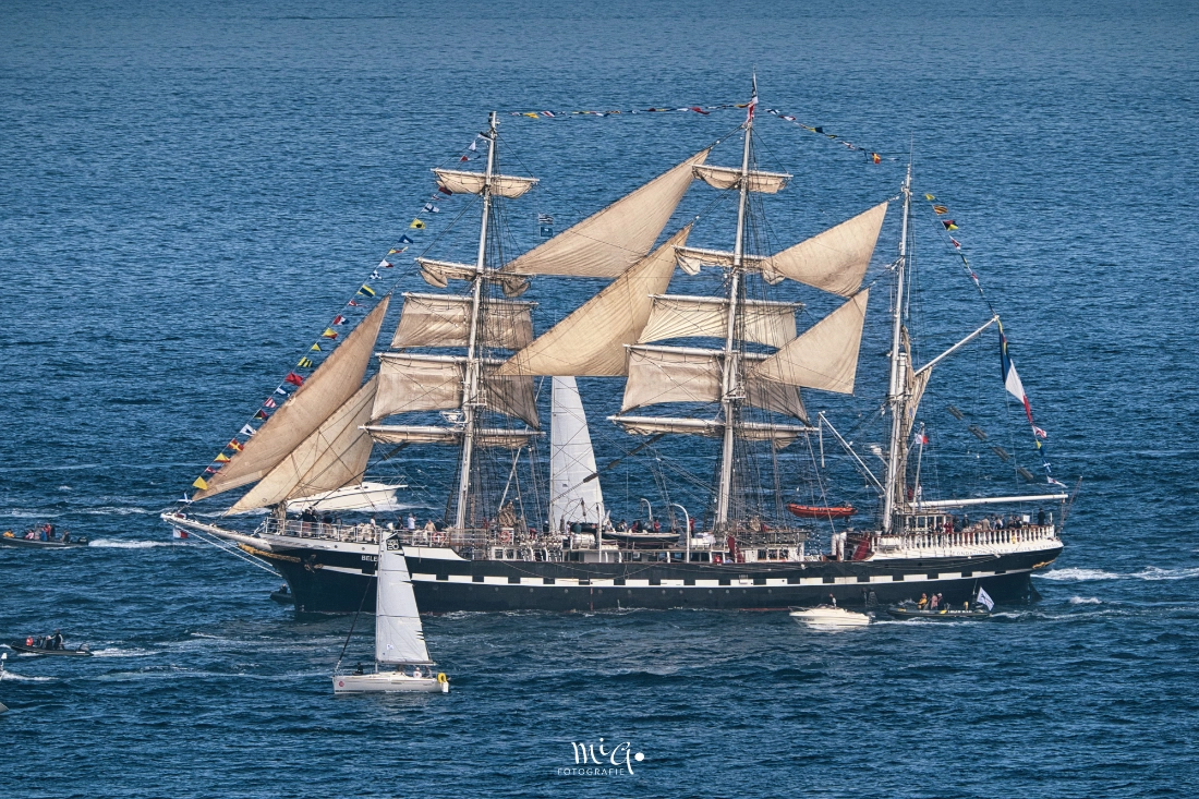 Der historische Dreimaster Belem unter Segeln mit Signalflaggen bei der Parade in Brest 2024