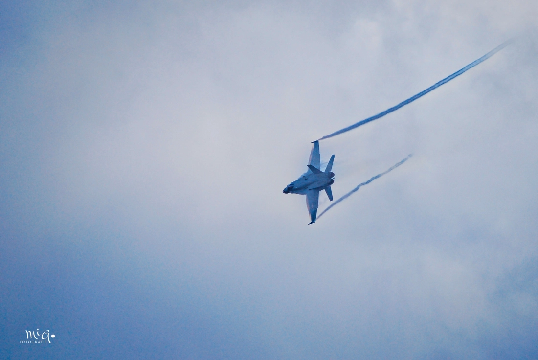 F/A-18 Hornet Kampfjet mit Vortex-Kondensstreifen und Rauch in einer steilen Kurve über Axalp 2007